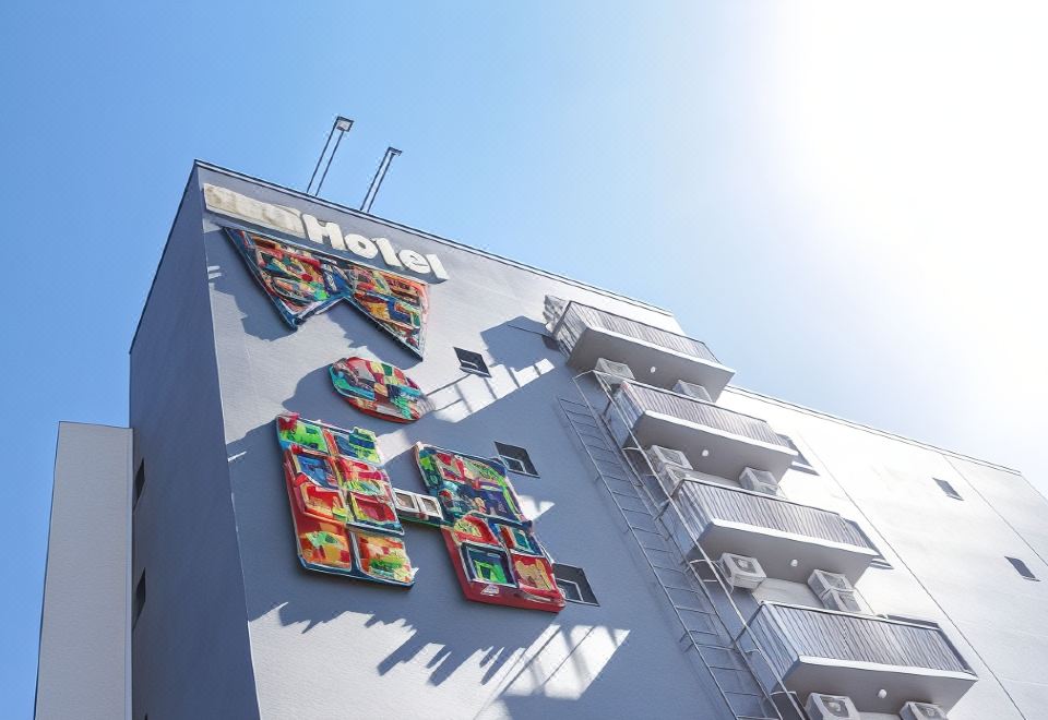 "a building with colorful sculptures of a letter "" h "" and the word "" hotel "" written on it" at Work Hotel