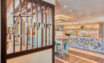 a bar with wooden walls and a metal grill , featuring blue stools and a counter with a sink at Premier Inn Bangor (Northern Ireland)