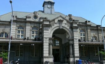 a large building with a clock tower and a blue sky , along with several bicycles parked in front of it at 101 Hotel