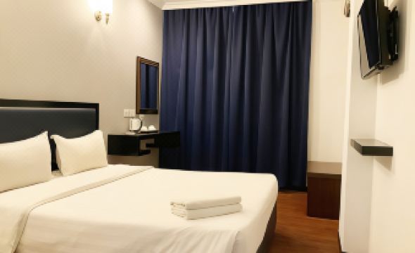 elegant bedroom featuring a white bed and blue curtains on the windowsill at Golden Hotel
