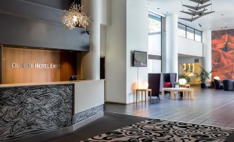 a modern hotel lobby with a reception desk , chairs , and a rug on the floor at Quality Hotel Entry