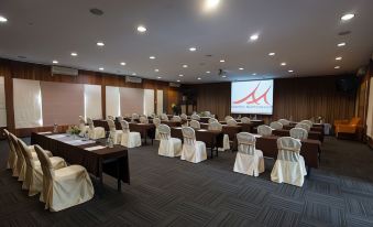 a conference room with rows of chairs arranged in a semicircle , and a projector on the wall at Baan Amphawa Resort & Spa