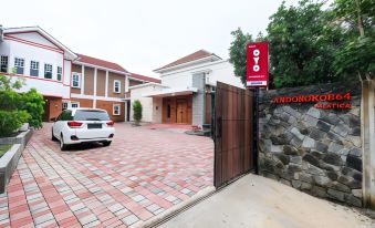 a driveway with a car parked in front of a house and an electric gate leading to the driveway at Super OYO Collection O 2383 Andongkoe 64 Salatiga