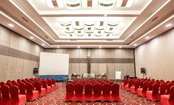 a large conference room with rows of red chairs arranged in front of a whiteboard , ready for a meeting or event at Aston Imperial Bekasi Hotel & Conference Center