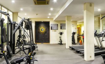 a well - equipped gym with various exercise equipment , such as treadmills , weight machines , and weight benches at Grand Pasundan Convention Hotel