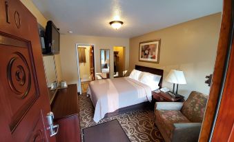 a well - furnished hotel room with a king - sized bed , a desk , a chair , and a tv at Jefferson Hills Motel