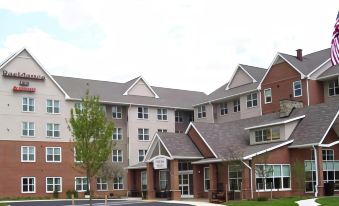 a large , modern apartment building with multiple stories and balconies , surrounded by a parking lot at Residence Inn Waldorf