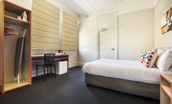 a modern hotel room with a bed , desk , and chair , as well as a door leading to another room at Granville Hotel