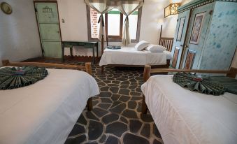 a hotel room with three beds , one on the left , one in the middle , and one on the right side at Eco Hotel Uxlabil Atitlan
