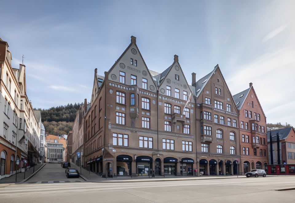 a large , three - story building with multiple windows and a red brick exterior is situated in an urban area at Clarion Hotel Bergen
