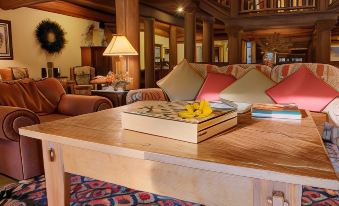 a cozy living room with a wooden coffee table , two couches , and a television mounted on the wall at Daniels Summit Lodge