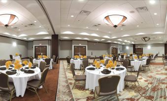 a large , well - lit banquet hall with multiple tables and chairs set up for a formal event at Hilton Garden Inn Columbia Airport