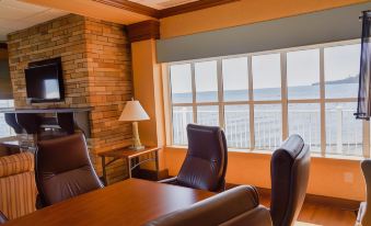 a conference room with a large window overlooking the ocean , featuring leather chairs and a wooden table at Rod 'N' Reel Resort