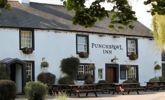 "a large white building with a sign that reads "" punchbowl inn "" prominently displayed on the front of the building" at The Punchbowl Inn