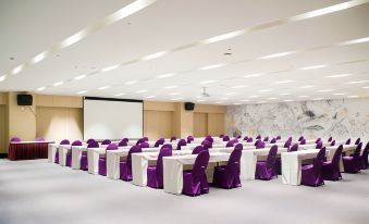a conference room with rows of chairs arranged in a semicircle , and a projector screen on the wall at Hotel Cham Cham
