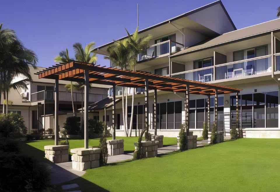 a modern house with a large glass canopy , surrounded by lush greenery and palm trees at Mercure Clear Mountain Lodge