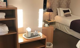 a hotel room with two beds , a nightstand , and a lamp , all decorated in a modern style at Duke of Wellington