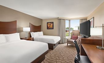 a hotel room with two beds , a tv , and a window overlooking the outdoors , along with a desk and chair at DoubleTree by Hilton Hotel Murfreesboro