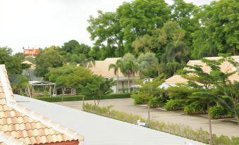 a residential area with multiple houses and trees , seen from an aerial view from a window at Saraburi Garden Resort