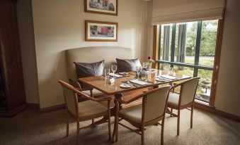 a dining room with a table set for four people , complete with chairs and wine glasses at Gateway on Monash