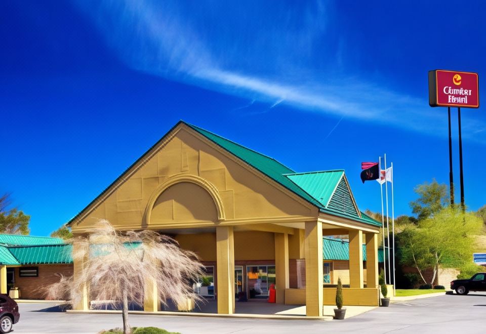 a large building with a green roof and two flags flying in front of it at Hotel Veranda DuBois