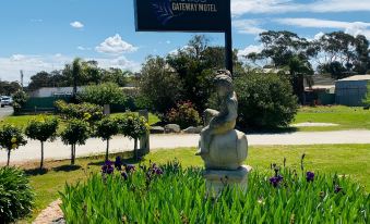 "a statue of a person is standing in a garden with a sign that says "" duchess "" below it" at Barossa Palms Motel