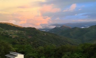 a serene mountain landscape with houses nestled in the hills , under a beautiful sunset sky at AYANA Holiday Resort