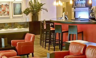 a modern lounge area with red leather chairs and a bar , creating a cozy atmosphere at The Upper House Hotel
