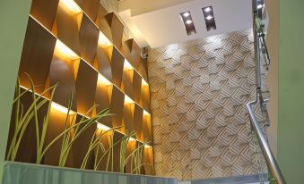 a modern interior design with gold and white geometric patterns , green plants , and a rectangular light source at Hotel Valentino