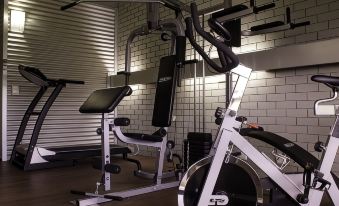 a well - equipped gym with various exercise equipment , including a weightlifting machine and a stationary bike at Morwell Motel