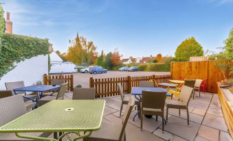 a rooftop patio with several tables and chairs , surrounded by a wooden fence and a parking lot at The Forest Lodge