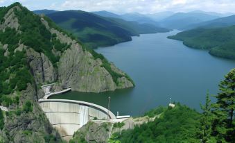 a scenic view of a lake with a large dam in the foreground and mountains in the background at Hotel THR Center