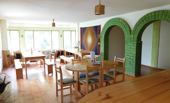 a dining room with wooden furniture , including a table and chairs , and a painting on the wall at La Casa Verde