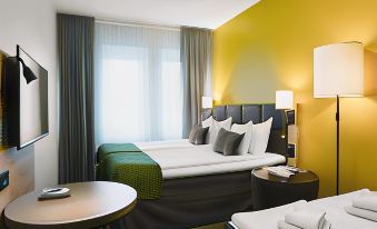 a modern hotel room with two beds , one on the left side and another on the right side at Quality Hotel Winn Haninge