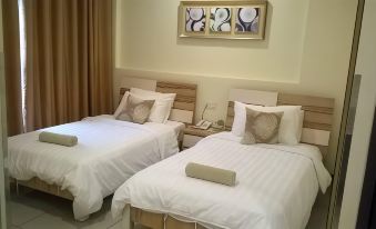 a hotel room with two beds , each made with white sheets and pillows , and a painting above them at My Inn Hotel Kota Samarahan