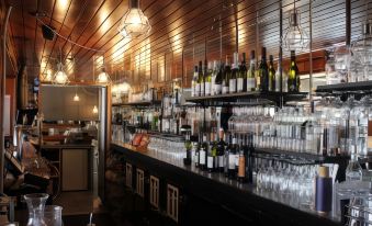 a bar with shelves filled with various bottles and wine glasses , creating a wine cellar atmosphere at Hotel Launceston