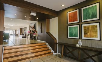 a modern interior with wooden stairs , abstract art on the walls , and a couch in the corner at Mercure Clear Mountain Lodge