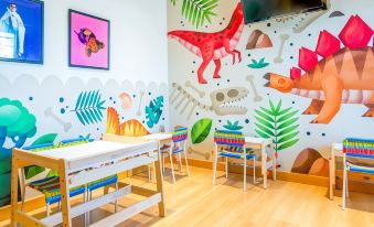 a dining room with a table and chairs , as well as a dinosaur - themed wall mural at Hotel Palacios