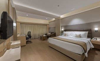 a modern hotel room with a large bed , desk , and couch , as well as a desk and chair at The Fern Residency Aurangabad