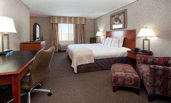 a hotel room with a king - sized bed , a desk , and a chair , as well as various office equipment at Holiday Inn Rock Springs