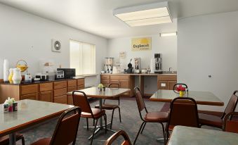 a dining area with tables and chairs , along with a coffee bar in the background at Days Inn by Wyndham Stoughton WI.