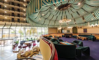 a modern , open - concept lounge area with multiple couches and chairs arranged around a central table at Hotel Holiday