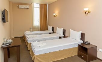 a hotel room with three beds , one on the left , one in the middle , and one on the right at Richmind Hotel