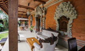 a living room with orange and white furniture , a wooden coffee table , and a potted plant at Ubud Hotel & Cottages