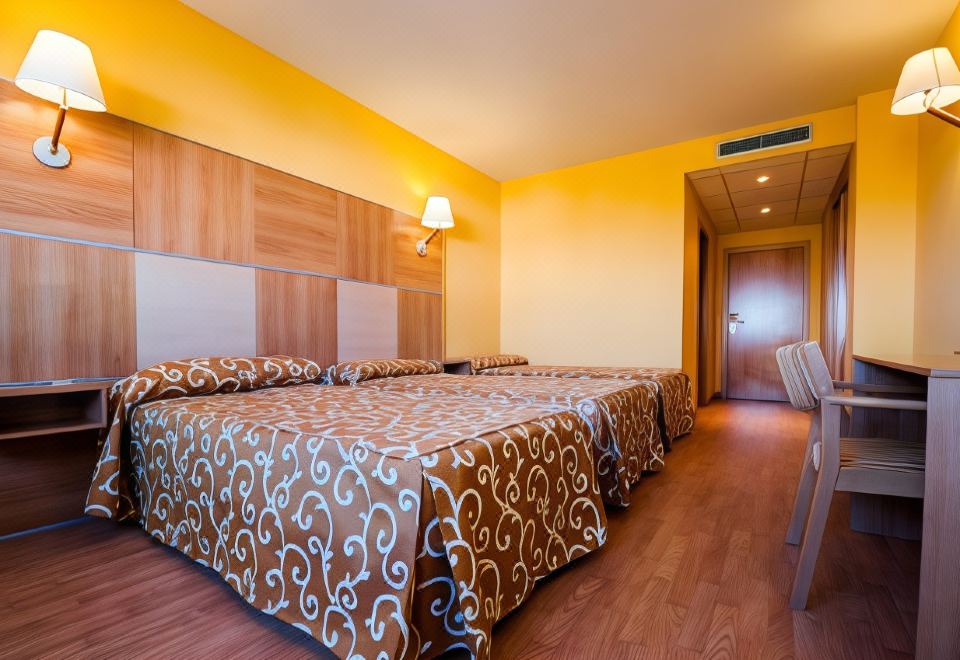 a hotel room with three beds , two of which are twin beds and one is a double bed at La Cañada