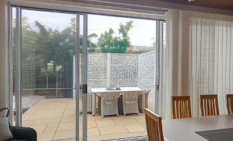 a dining room with a table and chairs , as well as a sliding glass door leading to an outdoor patio at Windarra on High