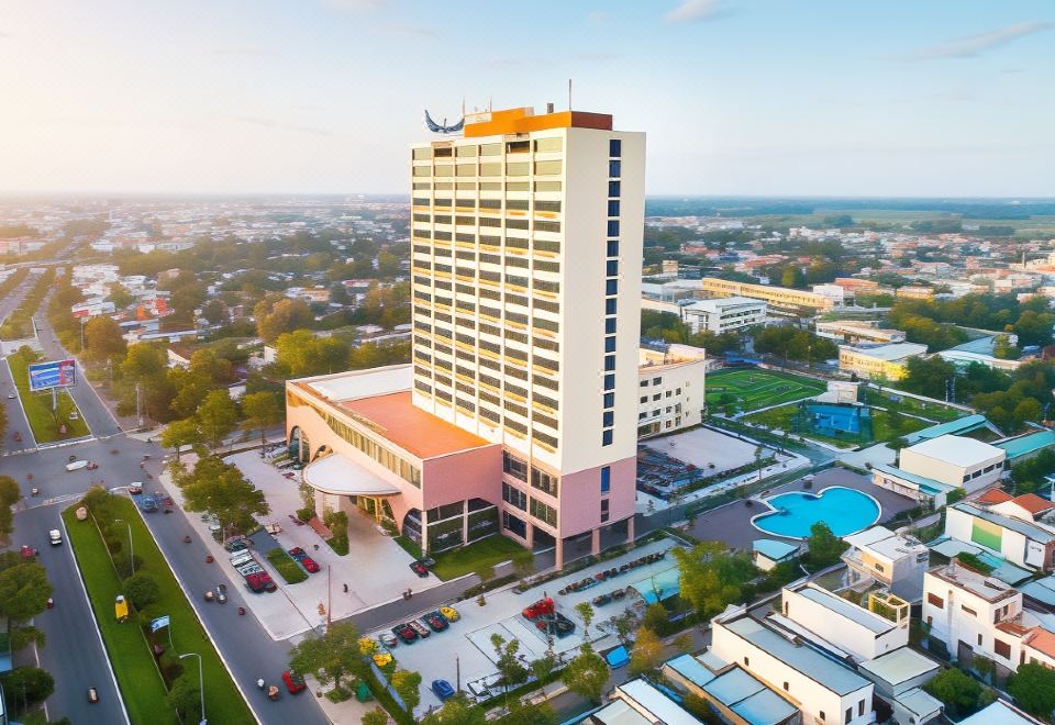 a large hotel building surrounded by a city , with a pool visible in the background at Muong Thanh Grand Quang Nam