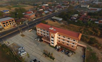 an aerial view of a city with a red - roofed building , surrounded by cars and buildings at Thatphanom View Hotel