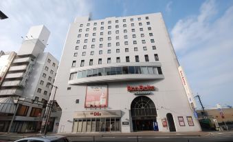 "a white building with a large sign that says "" bon ebolle "" and a red "" cafe "" on the side" at Airline Hotel