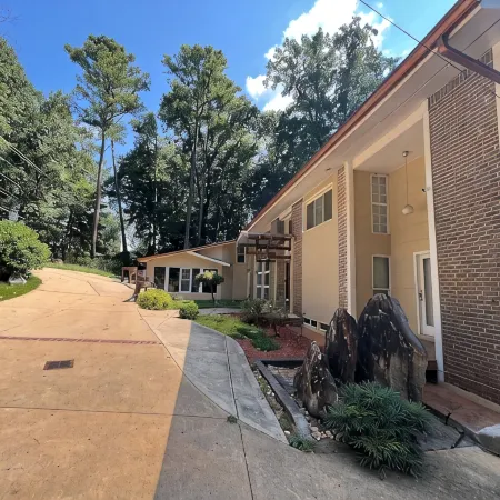5-Bedroom 6000SF wood and glass retreat in Atlanta, surrounded by greenery.